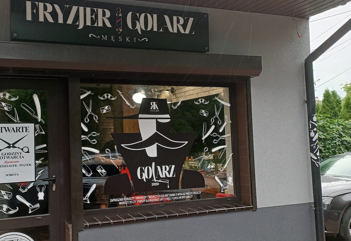 Szyld Fryzjer Golarz Męski i witryna z postacią w kapeluszu i z wąsem