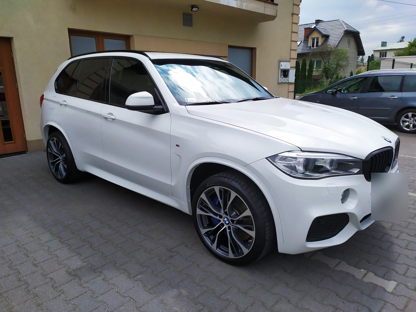 Białe BMW X5 przed studiem po detailingu