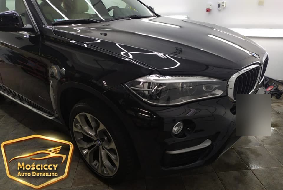 Czarne BMW X6 w hali po myciu i woskowaniu