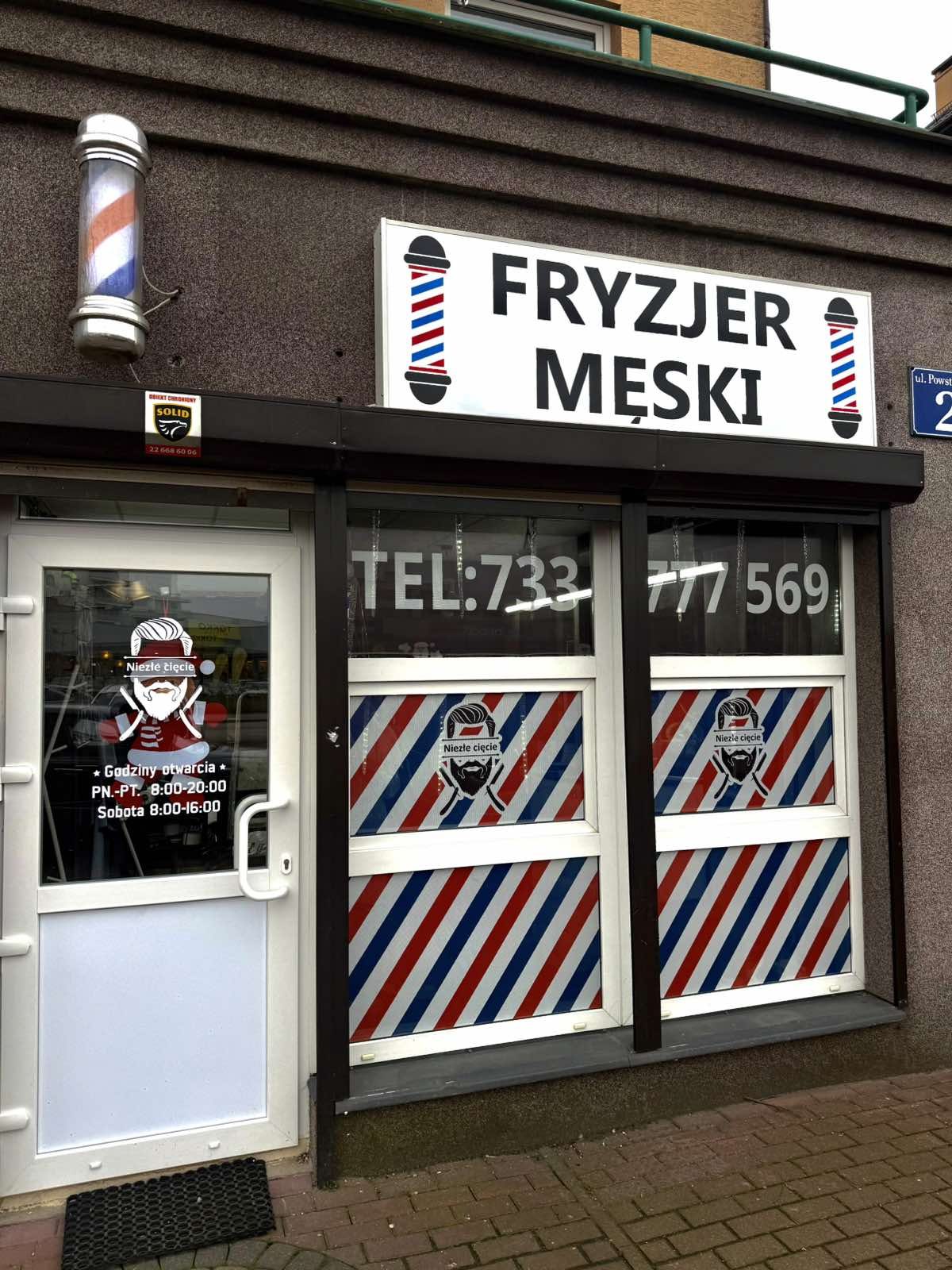 Witryna salonu z napisem Fryzjer męski i słupkiem barberskim
