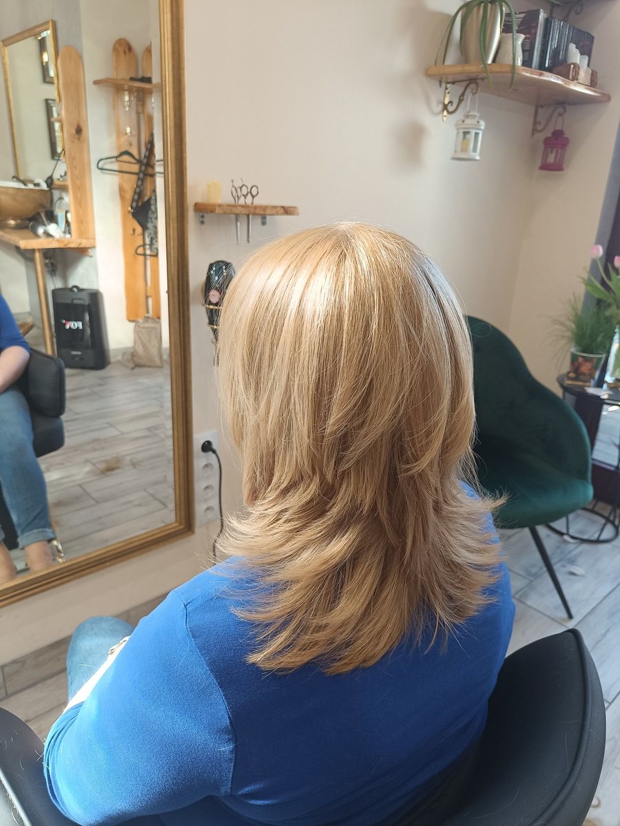 Cieniowane blond włosy do ramion, widok z tyłu, w tle lustro w złotej ramie